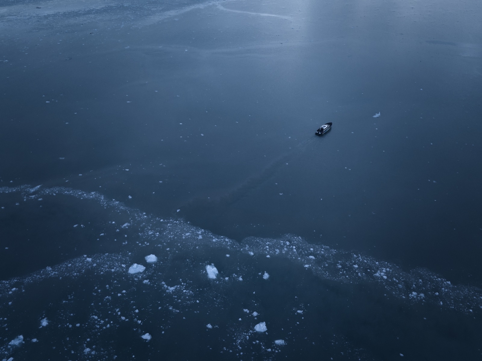 Sillage d’un navire électrique traversant une eau glacée, vu du ciel.